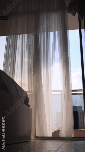 The curtain sways in the wind in the hotel room. Peace and comfort