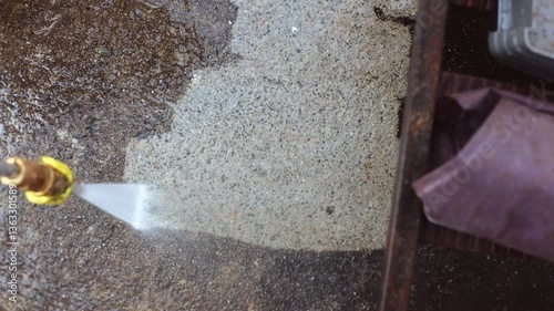 Cleaning cement backyard with power washer.