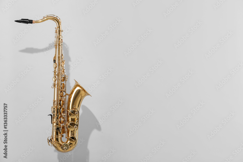 Fototapeta premium Golden saxophone on light grey background. Space for text