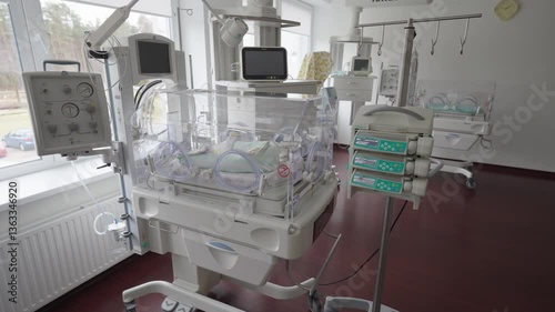Neonatal intensive care room with incubators, monitors, and IV pumps supporting premature babies in a modern hospital setting.
