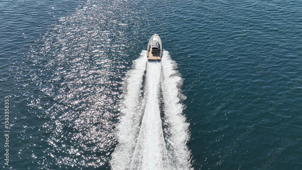 Aerial drone photo of luxury rigid inflatable speed boat cruising in high speed in Aegean deep blue sea, Greece
