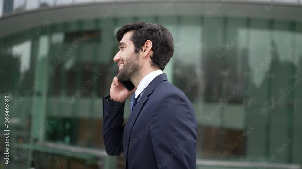 Skilled caucasian project manager calling phone while walking at city with blurred background. Skilled businessman using smart phone talking to project manager with blurred background. Exultant. Skilled caucasian project manager calling phone while walking at city with blurred background. Skilled businessman using smart phone talking to project manager with blurred background. Exultant.