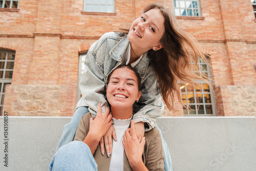 Vászonkép Two joyful young women happily embracing each other with genuine smiles, showcas