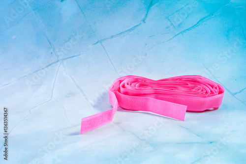 A beautiful roll of pink Velcro sits elegantly on a white surface