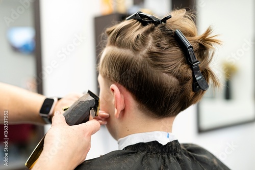 Teenager receiving a haircut at a salon and focused on personal style and grooming