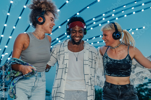 Friends listening music and walking at silent disco event