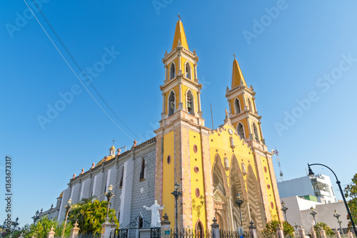 The striking yellow facade and bell towers of the Cathedral Basilica de la Inmaculada Conceptión, or Immaculate Conception Cathedral in Mazatlan, Mexico.	 photo