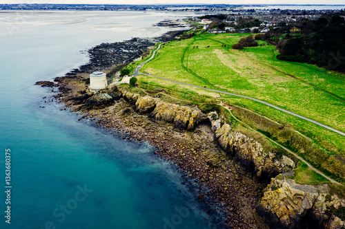 Aerial Drone View of the Irish Rocky Coastline With Martello Tower in Howth – Cliffs, Blue Sea and Lush Greenery photo
