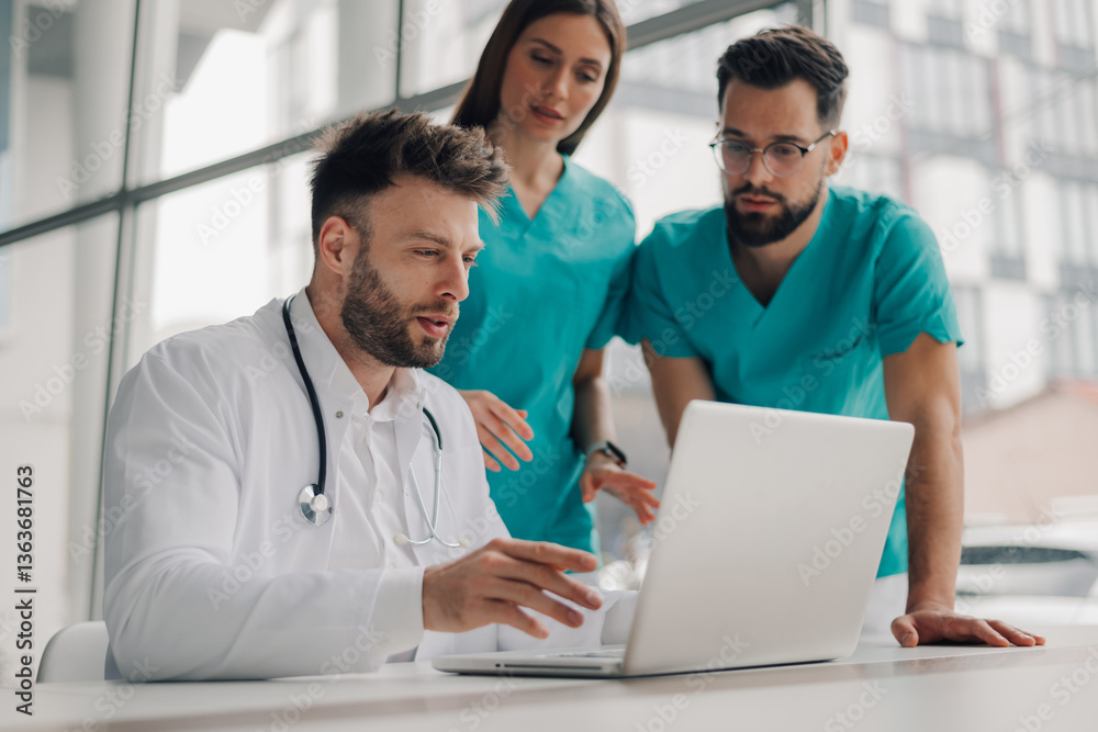 Medical team analyzing patient data on laptop in hospital Medical team analyzing patient data on laptop in hospital