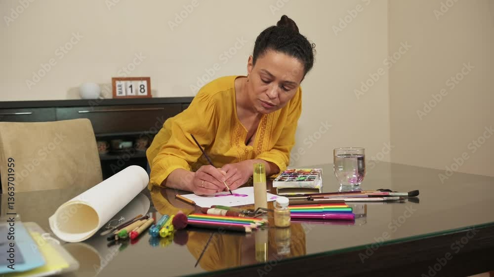 Woman Creating Art at Home with Various Tools on a Table Woman Creating Art at Home with Various Tools on a Table