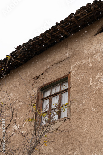Weathered Wooden Window on a Rustic Wall in Snow