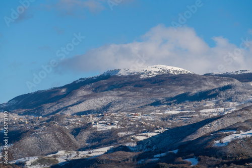 Valley Town Surrounded by Partially Snow-Capped Mountains
