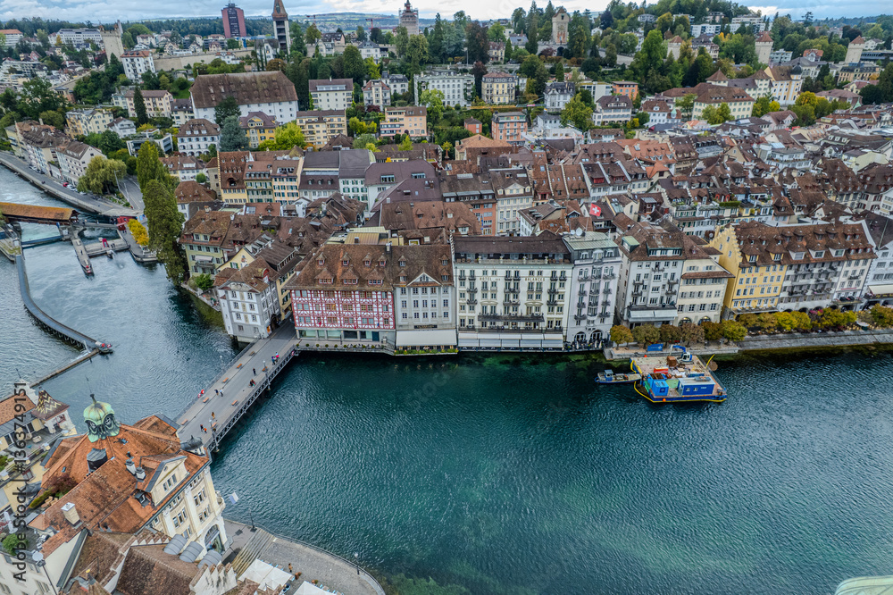 Obraz premium Stunning aerial footage of Kapellbrücke, the iconic Chapel Bridge, showcasing the picturesque beauty of Lucerne, Switzerland.