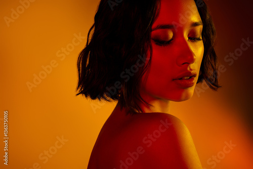 Dynamic and stylish portrait of a young woman with expressive lighting and vibrant orange background