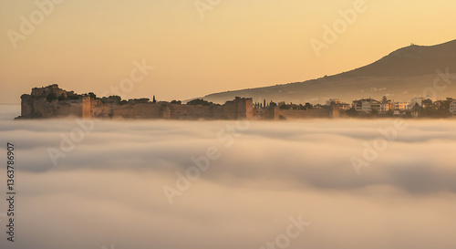 Enchanting Sunrise Above Misty Landscape Revealing Ancient Fortress, Highlighting the Magical Fusion of History and Nature in Golden Light