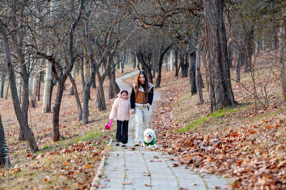 Fototapeta premium Pictures of two little girls while walking and playing with their white-collared dogs, they were the happiest and most joyful. Walking with dogs is one of the healthiest human activities.