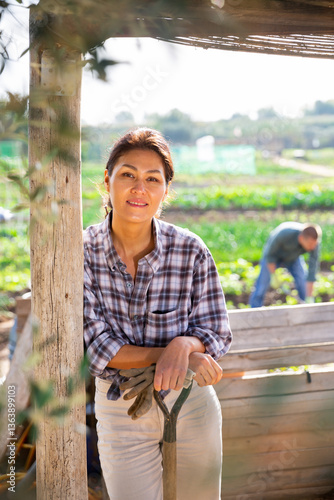 Asian woman working with shovel in vegetables garden outdoor