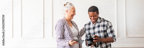 Obraz na płótnie Elderly woman and young man enjoying photography. Smiling woman and man with camera. Happy interaction between woman and man, sharing photography moments. Business partners working together. w salonie