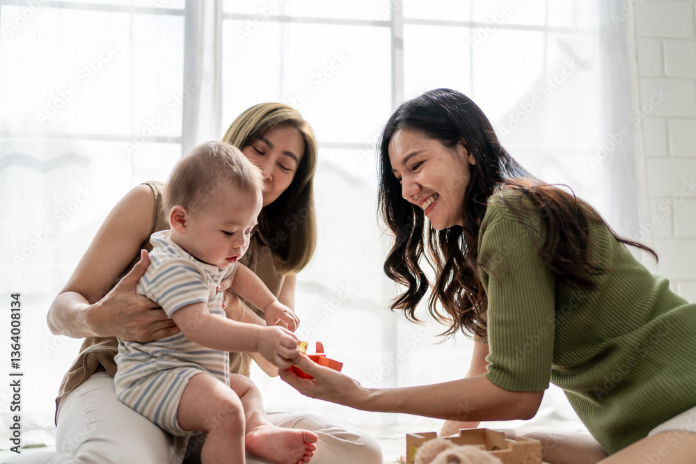 Asian lesbian couple lovingly caring for and raising their baby boy at home. Asian lesbian couple lovingly caring for and raising their baby boy at home.