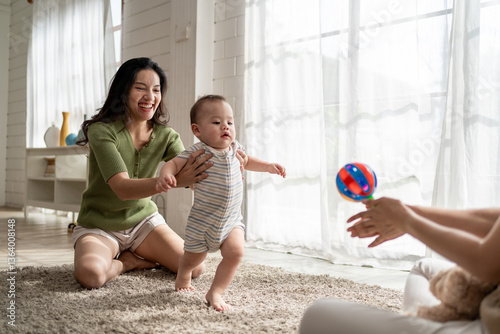Asian lesbian couple lovingly caring for and raising their baby boy at home. 