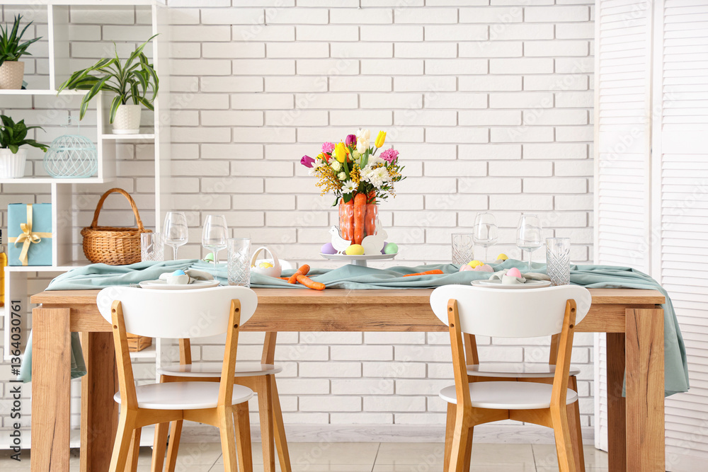 Obraz premium Beautiful table setting for Easter decorated with bouquet of carrots and flowers near white brick wall