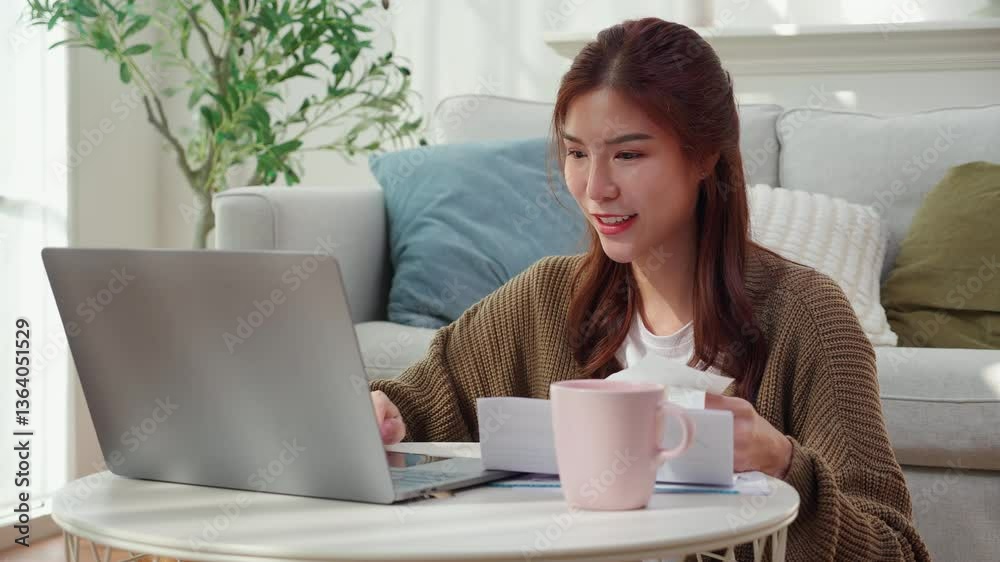 Young asian woman calculates bills finance and cost in living room at home, woman looking expense with burden or investment on paperwork, statement banking and debt for loan, business and financial. Young asian woman calculates bills finance and cost in living room at home, woman looking expense with burden or investment on paperwork, statement banking and debt for loan, business and financial.