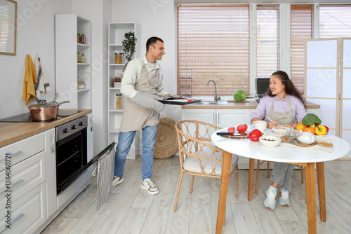 Young couple baking vegetab...