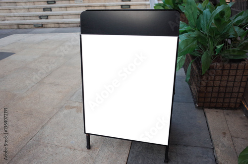 Obraz na płótnie Blank white outdoor advertising stand or sandwich board mock up template. Clear street signage board placed by an outdoor dinning area of a restaurant. Background texture of standee on street. w salonie