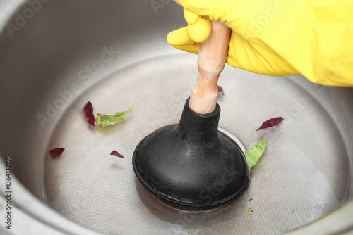 Woman cleaning clogged kitc...