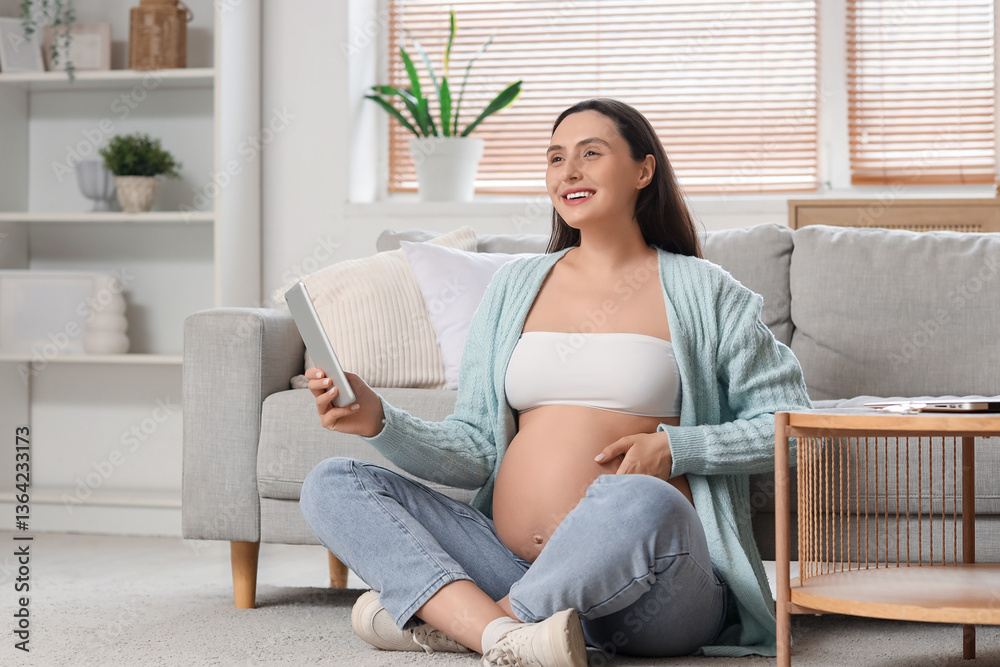 Young pregnant woman using tablet computer on floor at home Young pregnant woman using tablet computer on floor at home