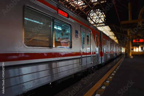 Wallpaper Mural the commuter city train moves forward leaving the station,  The train has multiple passenger car, Overhead power lines hang down from the station structure. around the platform area Torontodigital.ca