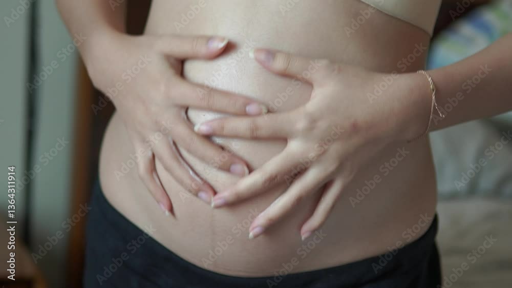 Close up of young Asian pregnant woman touching and caressing her stomach belly. Close up of young Asian pregnant woman touching and caressing her stomach belly.