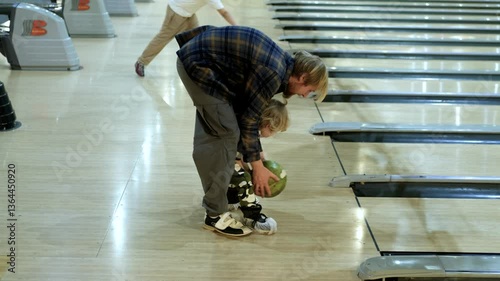 father and little son playing bowling