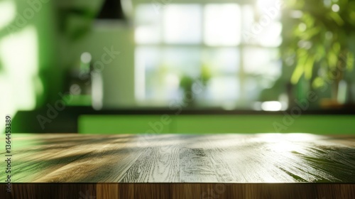 Empty wooden table in a modern green kitchen with sunlight streaming through the window.