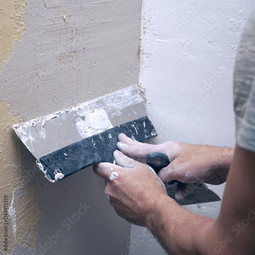 A man plastering a wall with a spatula