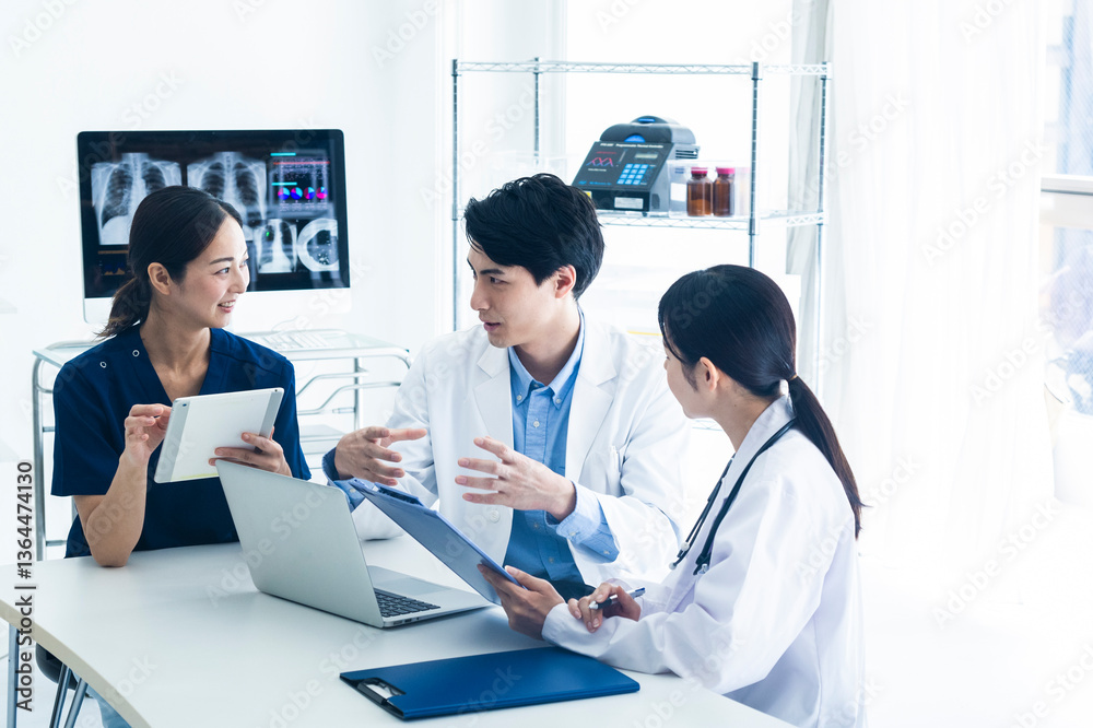 Medical Team Discussing Patient Data with Digital Devices.A group of medical professionals including doctors and a nurse are having a meeting in a bright office. They are reviewing patient information Medical Team Discussing Patient Data with Digital Devices.A group of medical professionals including doctors and a nurse are having a meeting in a bright office. They are reviewing patient information
