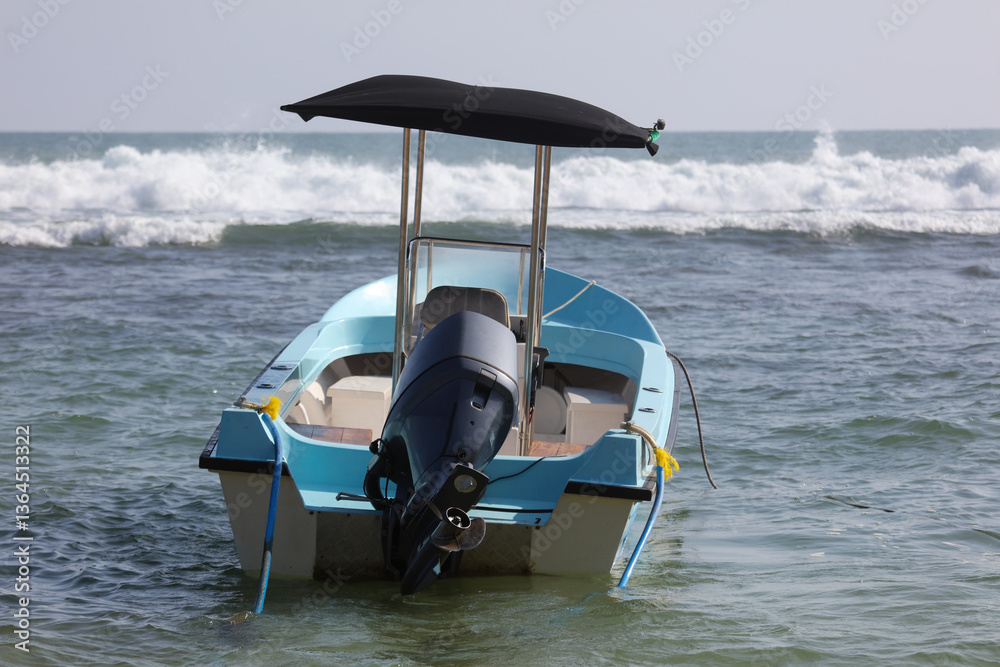 Naklejka premium A small blue boat with a black canopy is sitting in the water