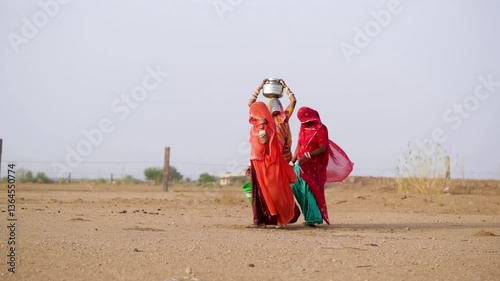 Women collecting in water in a desert in Rajasthan, India