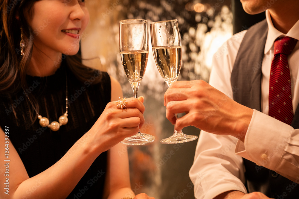 A woman in formal black attire touches her earring while smiling and engaging in conversation with her date at a high-end bar. The warm lighting and her expressive face emphasize a sense of romance