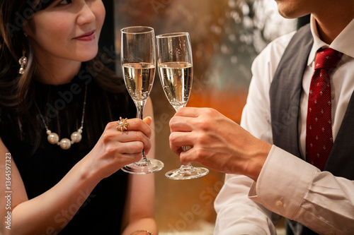 Obraz na płótnie Detailed close-up shot of two champagne flutes clinking together during a toast at an elegant bar. The hands, jewellery, and bubbles emphasize sophistication and celebration. w salonie