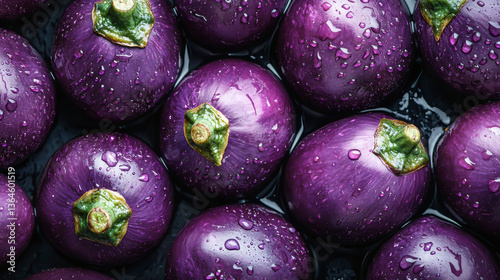 Moist and glossy eggplants arranged beautifully against a dark seamless background showcasing their texture and color
