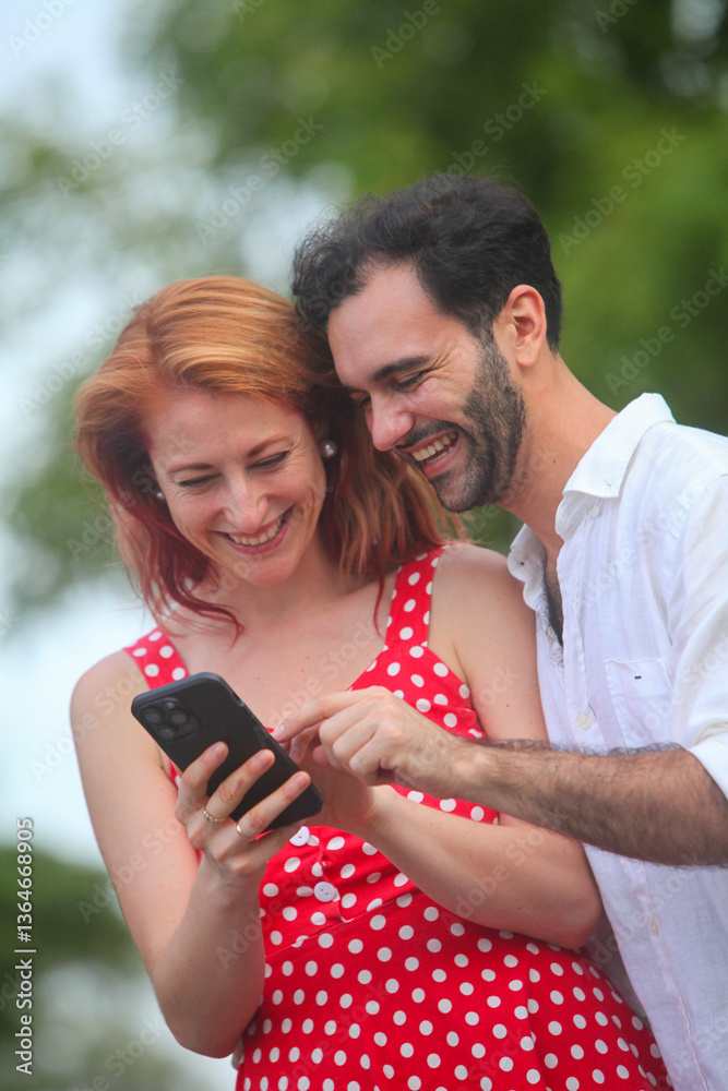 portrait of cheerful young couple in love using smartphone outdoors smiling portrait of cheerful young couple in love using smartphone outdoors smiling