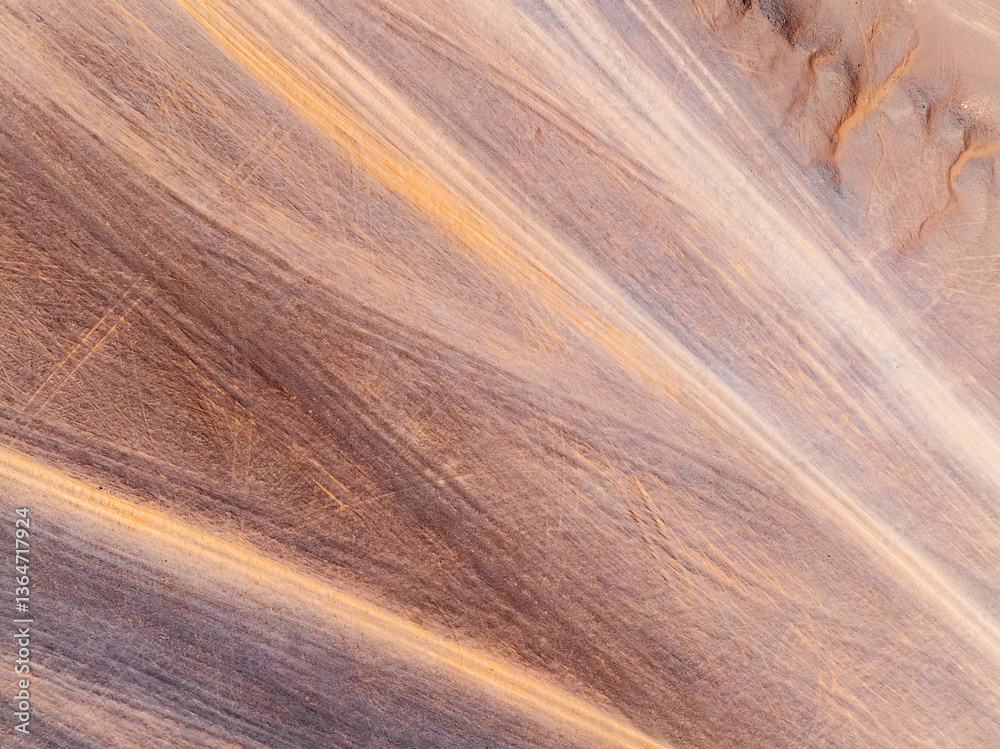 Aerial view of desert sand texture background. An abstract ground texture reveals natural patterns and tire track.