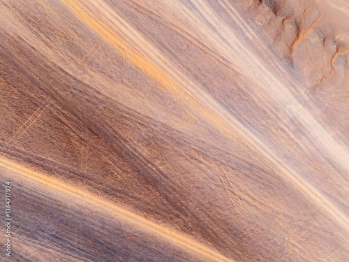 Obraz na płótnie Aerial view of desert sand texture background. An abstract ground texture reveals natural patterns and tire track. w salonie