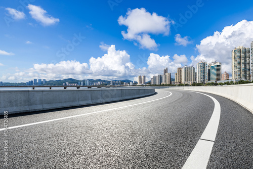 Obraz na płótnie Asphalt road leading to the modern city under blue sky w salonie