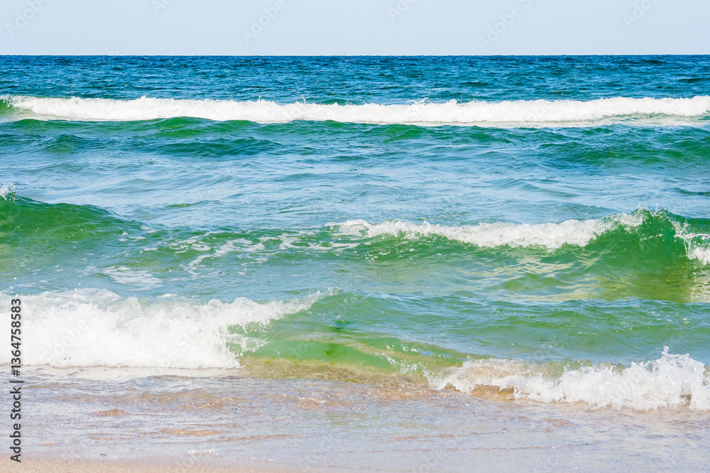 sea scenery in summer. beach with golden sand. wonderful vacation background with transparent calm waves and blue sky. green water