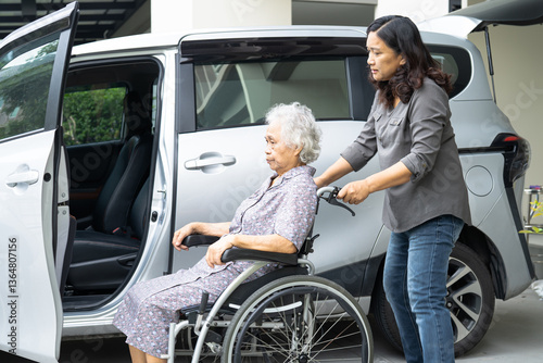 Caregiver help and support asian elderly woman sitting on wheelchair prepare get to her car to travel in holiday.