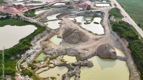 Aerial Mining Site Excavation Impact on Landscape with Ponds, Sand Mounds, and Greenery, Showcasing Environmental Changes in Natures Terrain