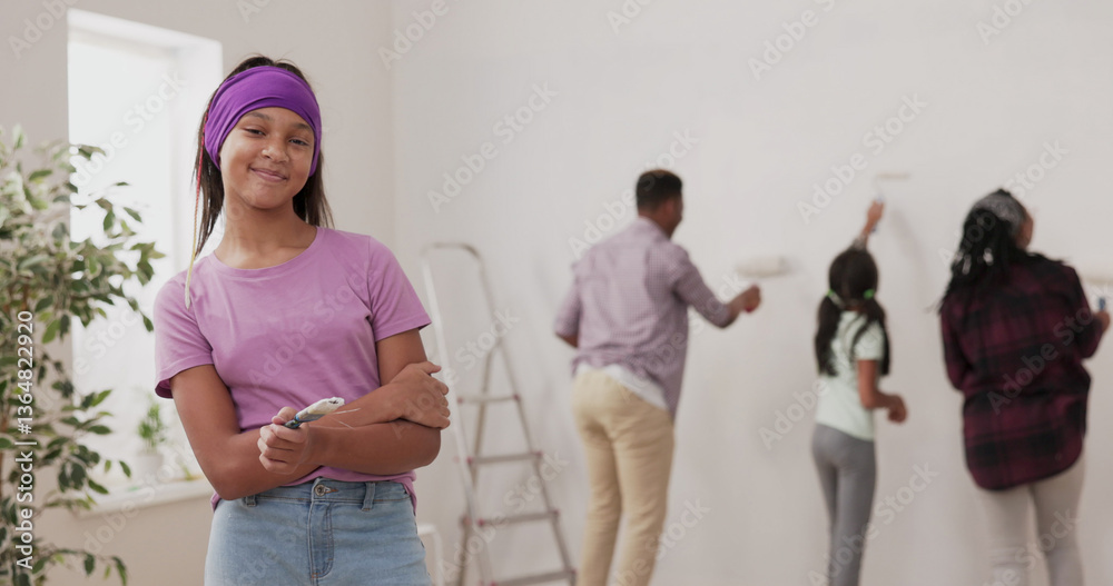 Fototapeta premium A smiling girl in a purple blouse and headband looks into the camera, holding a paintbrush, laughing. In the background, a family paints the walls next to a ladder during the apartment renovation.