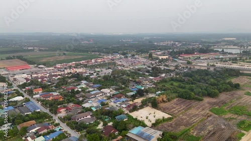 Aerial View of Suburban Landscape Vibrant Community of Residential Homes, Greenery, and Rooftops Blending Nature with Industrial Elements